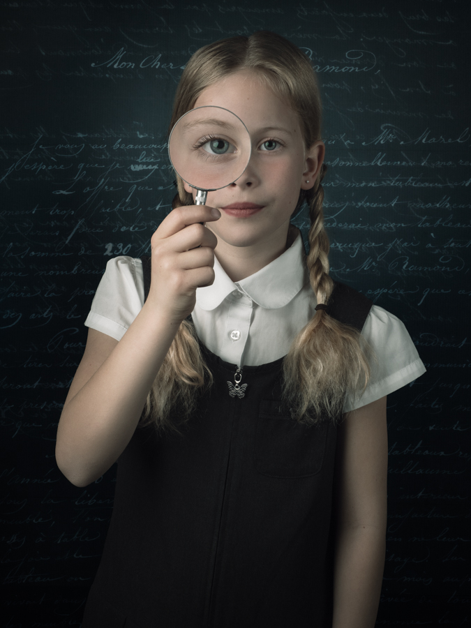 Meisje met blonde haren, Engels school uniform en vergrootglas voor het oog